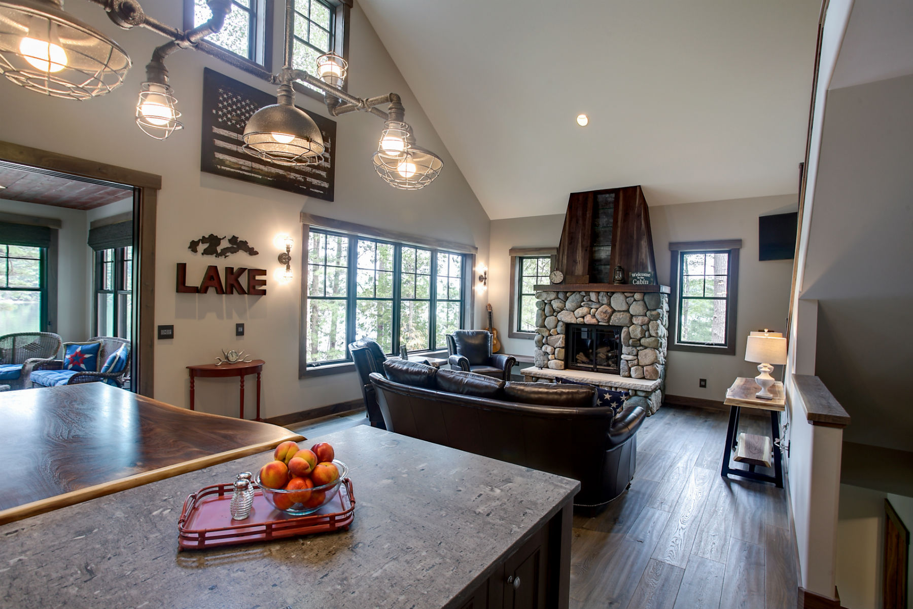 The Lodge's industrial-chic great room with a gas fireplace and lake views